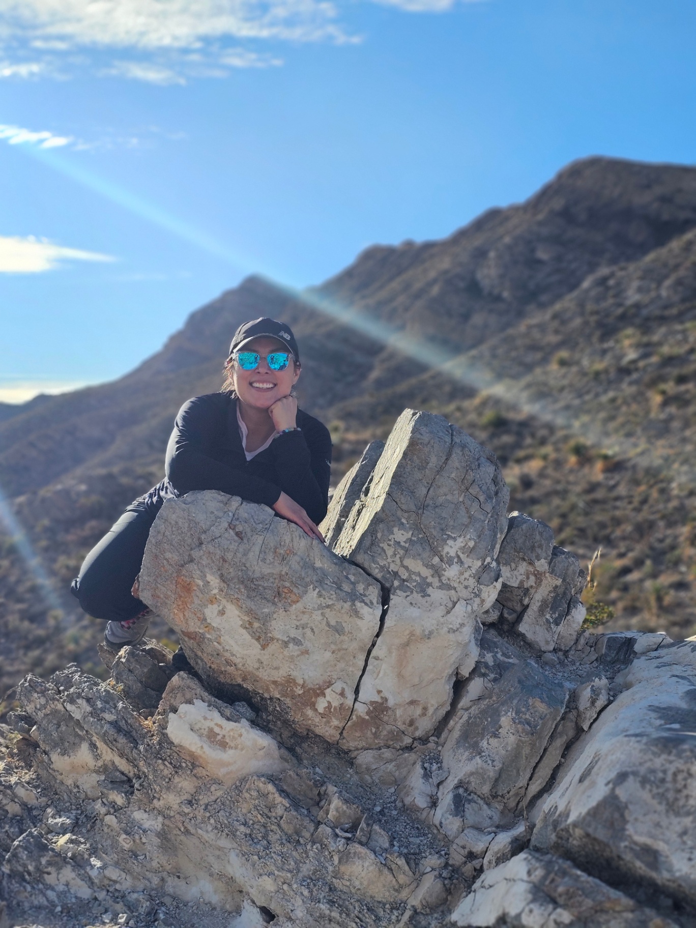 Woman resting on limestone rocks along a desert mountain ridge