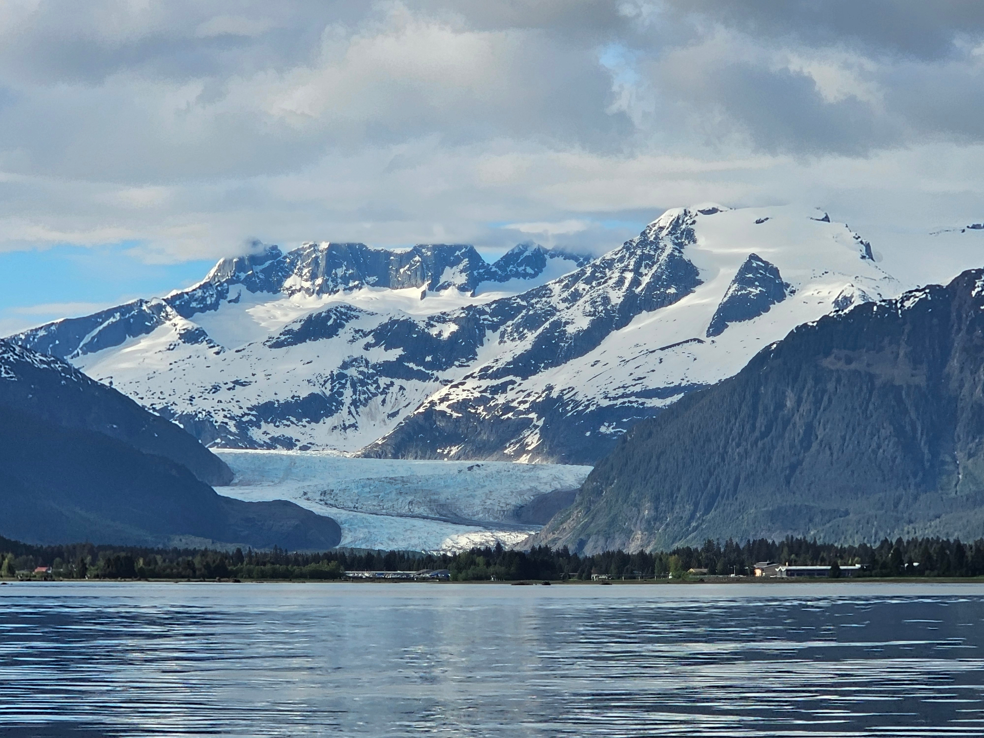 Glacier flowing between snowy Alaskan peaks