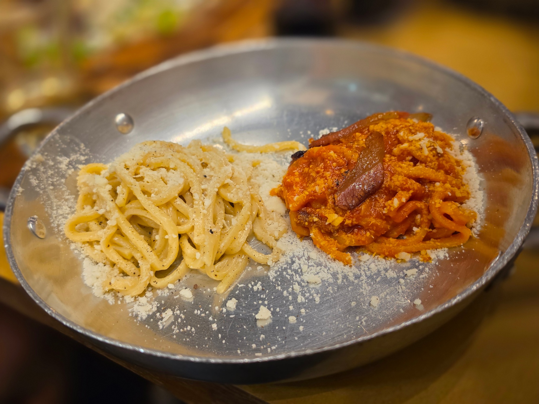 Cacio e pepe and amatriciana served in a metal pan
