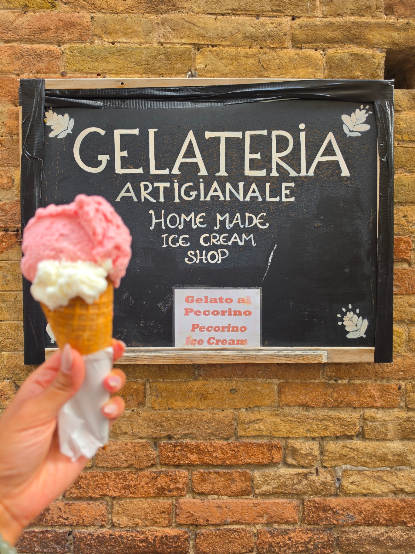 Gelato cone in front of a gelateria sign