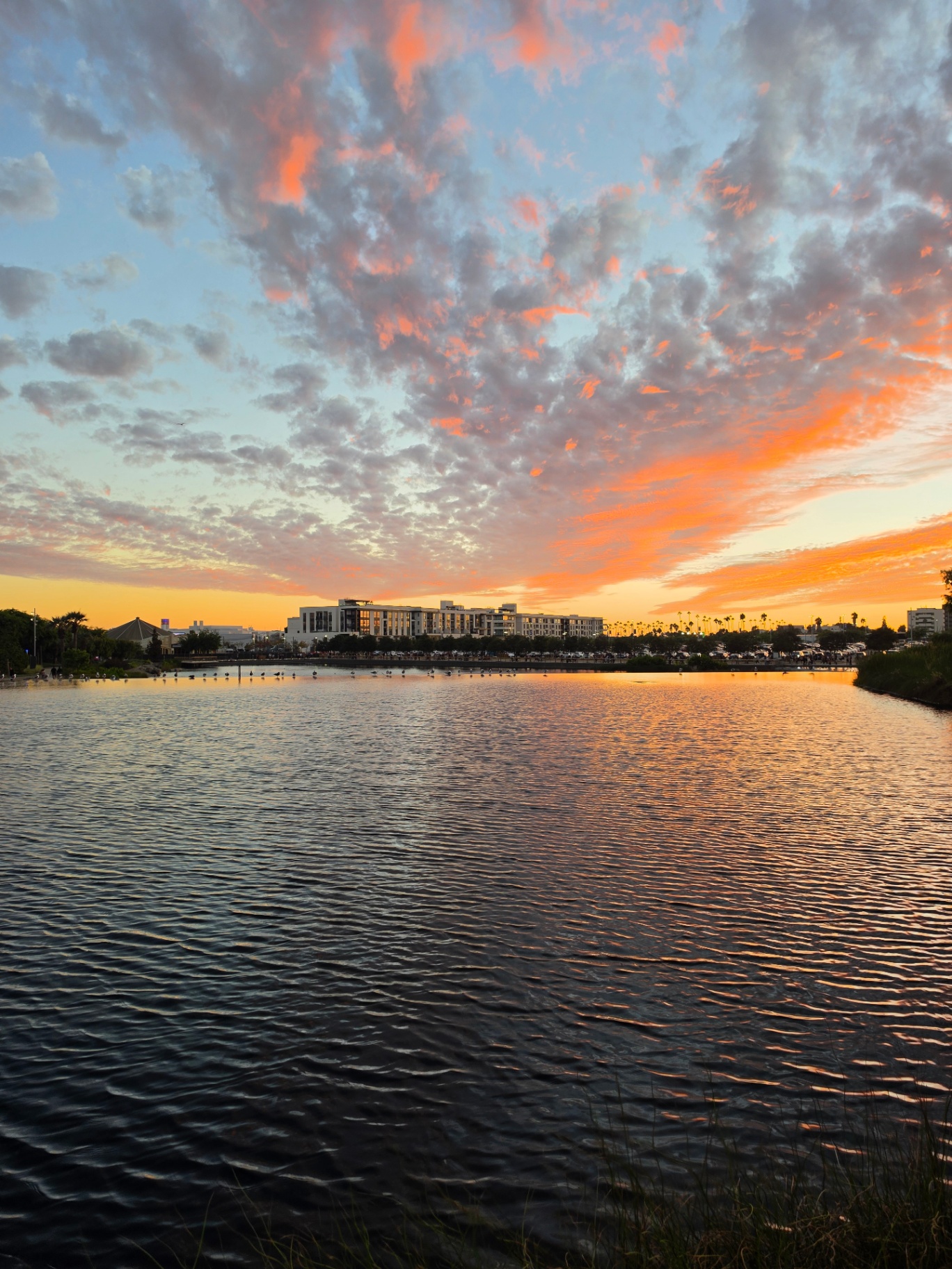 Orange sunset clouds mirrored in a calm lagoon